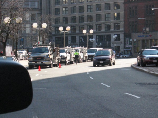 Boston police officer riding opposite traffic in the door zone
