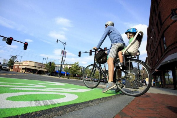 "A bike box is a designated area at the head of a traffic lane at an intersection that provides bicyclists with a safe and visible way to get ahead of queuing traffic during the red signal phase."